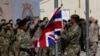 FILE - British troops lower the Union flag during a ceremony marking the end of operations for U.S. Marines and British combat troops in Helmand, Afghanistan, Oct. 26, 2014. 