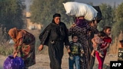 Civiles huyen durante el bombardeo turco en la ciudad de Ras al-Ain, en el noreste de Siria, en la provincia de Hasakeh, a lo largo de la frontera turca, el 9 de octubre de 2019.
