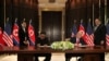 U.S. President Donald Trump and North Korea's leader Kim Jong Un sign documents that acknowledge the progress of the talks and pledge to keep momentum going, after their summit at the Capella Hotel on Sentosa island in Singapore, June 12, 2018. 