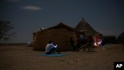 Tigrayan refugees who fled the conflict in the Ethiopia's Tigray try to find a network signal for their mobile phones in Hamdayet, eastern Sudan, near the border with Ethiopia, on March 23, 2021. (AP Photo/Nariman El-Mofty)