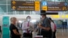 Petugas bandara memeriksa warga Australia setibanya di bandara internasional Ngurah Rai, Bali, 18 Agustus 2021. (AP Photo/Firdia Lisnawati)
