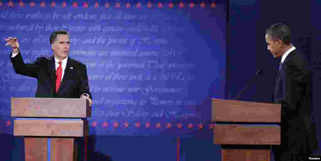 President Barack Obama (R) listens as Republican presidential nominee Mitt Romney speaks during the debate in Denver.