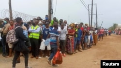 Des personnes attendent l'arrivée d'un navire transportant plus de 1000 personnes fuyant une attaque revendiquée par des insurgés liés à l'État islamique sur la ville de Palma, sur les quais de Pemba, au Mozambique, le 1er avril 2021.