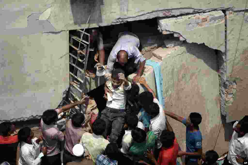 Seorang pria yang terperangkap berhasil diselamatkan dari balik reruntuhan bangunan delapan lantai di Savar, sekat Dhaka, Bangladesh, 24 April 2013.