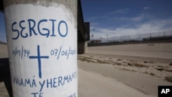 FILE - Graffiti is seen at the site where Sergio Hernandez was shot dead in 2010 under a railroad bridge connecting El Paso with Ciudad Juarez, July 1, 2014.