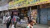 FILE - Kenyans walk past closed shops in the capital after an attack on a hotel complex, claimed by al-Shabab, in Nairobi, Kenya, Jan. 18, 2019.