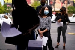 FILE - People stand in line, resumes in hand, while waiting to apply for jobs during an outdoor hiring event for the Circa resort and casino, in Las Vegas, April 27, 2021.