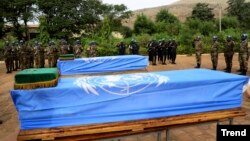 Des soldats Maliens et de la Mission de l'ONU au Mali (MINUSMA) rendent hommage à deux casques bleus tués dans un attentat, Bamako, le 18 décembre 2013. 