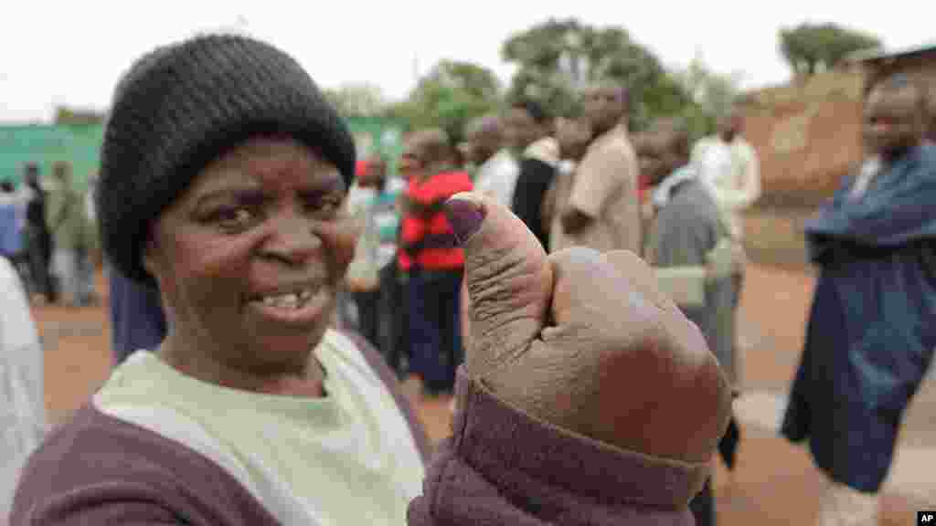 Une femme montre son pouce taché d'encre après avoir placéson vote dans l'urne le jour de l'élection présidentielle à Lusaka, 20 janvier 2015.