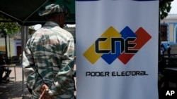 Un militar hace guardia al lado de una imagen institucional del CNE en Caracas, Venezuela, l 16 de abril de 2024.