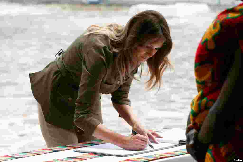 U.S. first lady Melania Trump signs a visitors book during a visit to Cape Coast castle, Ghana, October 3, 2018.