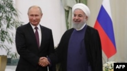 El presidente ruso, Vladimir Putin (izq.),y el presidente iraní, Hassan Rouhani, se dan la mano durante la reunión, en Teherán.
