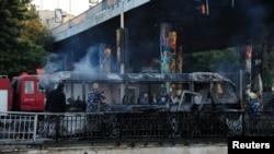 Para petugas memadamkan api yang membakar sebuah bus setelah serangan bom di pinggir jalan di kota Damaskus, Suriah, terjadi pada 20 Oktober 2021. (Foto: SANA/Handout via Reuters)