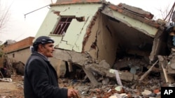 Seorang warga berjalan di antara reruntuhan rumah yang hancur di Silopi, Turki (19/1). 