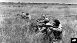 Les soldats de la MPLA s'entraînent dans un champ en 1976, en Angola. 
