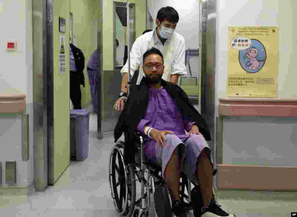 Ken Tsang (tengah) anggota partai politik pro-demokrasi lokal, dibawa ke rumah sakit menyusul bentrokan antara demonstran dengan polisi di Hong Kong (15/10).