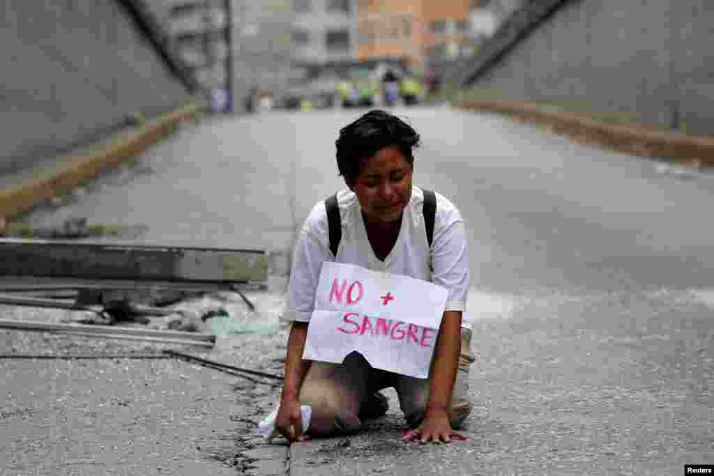 Seorang remaja putri menangis di lokasi di mana demonstran anti pemerintah Neomar Lander (17 tahun) tewas dalam aksi protes menentang Presiden Nicolas Maduro di Caracas, Venezuela.