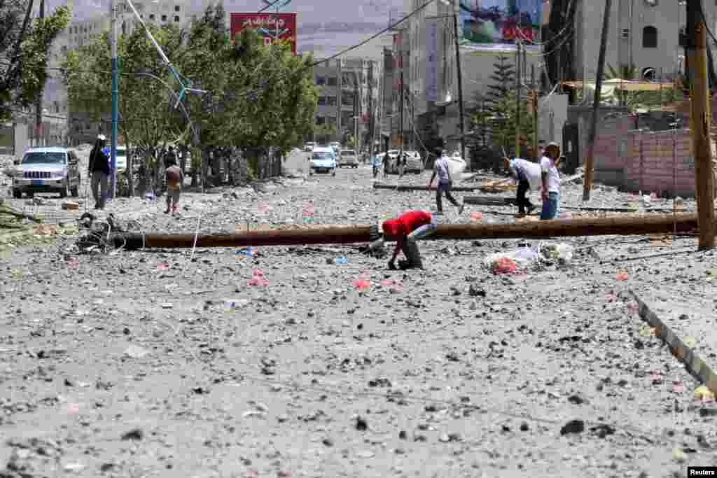 A boy finds an artillery shell on a street that was hit by an April 20 airstrike. The strike hit a nearby army weapons depot, in Sana'a, April 21, 2015.