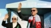 Presiden Turki Recep Tayyip Erdogan (kanan) dan istrinya Emine Erdogan (kiri) menyapa para pendukungnya dalam rapat umum yang diselenggarakan oleh partai AKP dalam solidaritas dengan Palestina di Gaza, di Istanbul pada 28 Oktober 2023. (Foto: AFP)