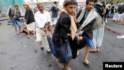 Pemberontak Syiah Houthi mengangkut korban luka-luka dalam serangan bom di Sana'a.