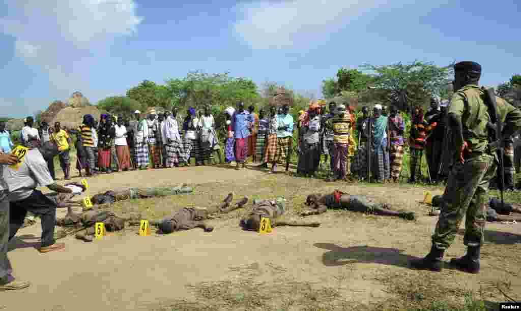 Villagers and police view the bodies of suspected attackers from the Pokomo tribe, following tribal clashes in Kipao village in the Tana River Delta region of southeastern Kenya Dec. 21, 2012.