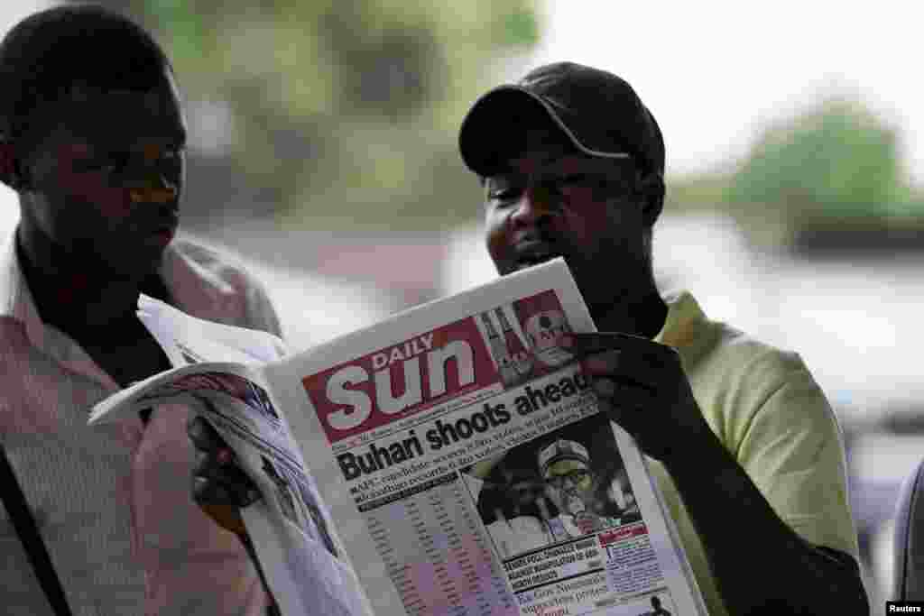 Seorang pria membaca surat kabar dengan berita utama mengenai pemilu, di Port Harcourt (31/3). (Reuters/Afolabi Sotunde)