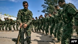 Borci Sirijskih demokratskih snaga (SDF), koje predvode Kurdi a podržava Amerika, u blizini naftnog polja Omar u istočnoj Siriji, igraju nakon proglašenja totalne eliminacije i posljednjeg bastiona Islamske države (IS), 23. marta 2019.