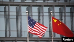 美中国旗在一家美国公司驻北京的办公楼外飘扬（路透社2021年1月21日）
