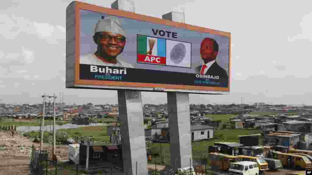 Un panneau d’affichage électronique du candidat de l'opposition présidentielle, Muhammadu Buhari, du parti tous les progressistes Congrès et son colistier, Yemi Osinbanjo est apperçu dans un bidonville de Lagos, au Nigeria, mardi 24 mars2015.