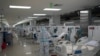 Trabajadores de la salud, voluntarios españoles de la Fundación SAMU y médicos salvadoreños asisten a pacientes ingresados en la unidad de cuidados intensivos durante la pandemia de COCIVD-19, en San Salvador, el 12 de agosto de 2020. 