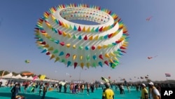 Warga India menyaksikan layang-layang raksasa yang tampil dalam Festival Layang-layang Internasional di Ahmadabad, India, 6 Januari 2019.