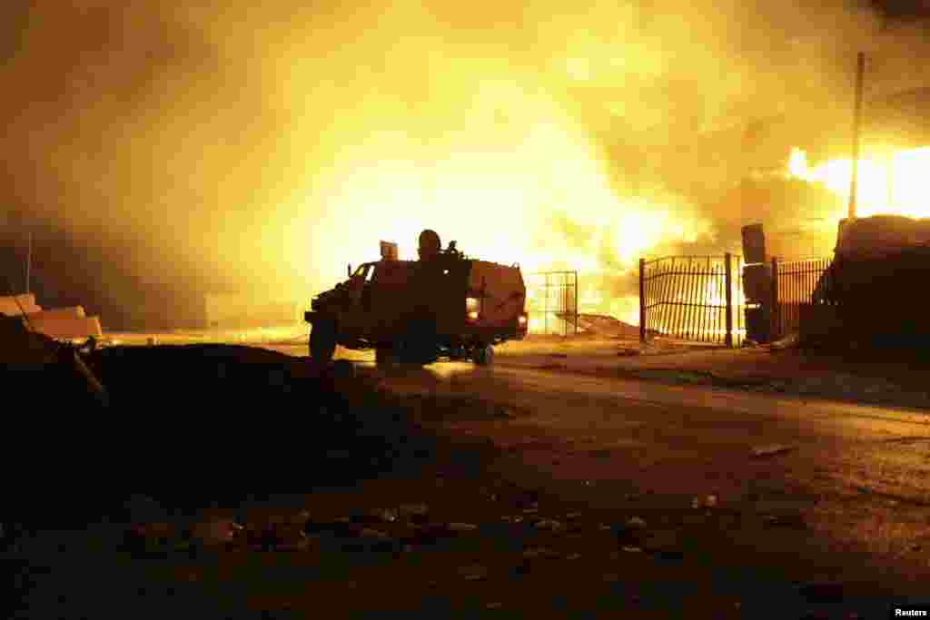 A building on fire, which witnesses said was hit by a rocket, burns after clashes between rival militias in the Sarraj district in Tripoli, Aug. 23, 2014.
