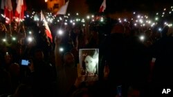 Protestors hold up pictures of slain journalist Daphne Caruana Galizia during a demonstration outside Malta's prime minister's office in Valletta, Malta, Nov. 26, 2019.