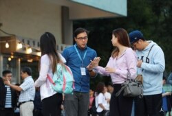 Electoral staff helps a voter at a polling station during district council local elections in Hong Kong, Nov. 24, 2019.