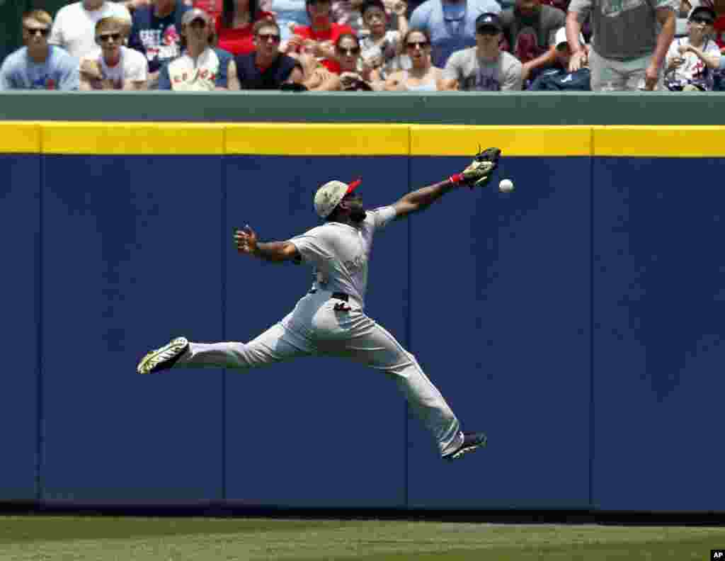 Boston Red Sox outfielder Jackie Bradley tries to reach a 2-RBI double hit over his head by Atlanta Braves' Justin Upton during the third inning of a baseball game in Atlanta, Georgia, USA, May 26, 2014.