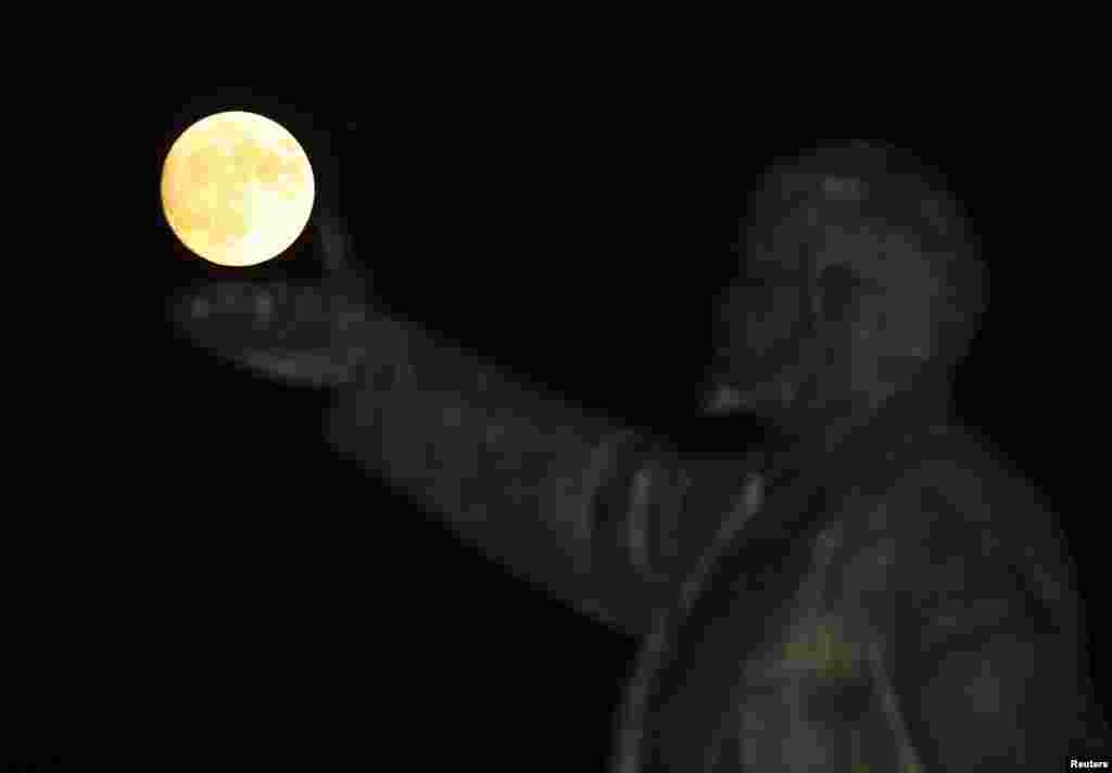 A full moon rises behind a statue of Soviet state founder Vladimir Lenin on the eve of the "supermoon" spectacle, Baikonur, Kazakhstan.