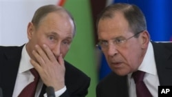 El presidente ruso, Vladimir Putin, habla con su canciller, Sergei Lavrov, en una ceremonia este lunes en el Kremlin.