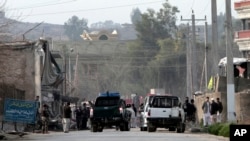 Para petugas keamanan tengah menginvestigasi lokasi ledakan bom bunuh diri yang menewaskan dan melukai beberapa orang di dekat gerbang Direktorat Nasional Keamanan wilayah Jalalabad, Afghanistan (24/2).