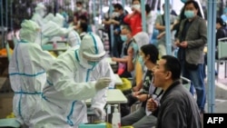 武漢一名醫務人員正在對一位市民進行新冠狀病毒檢測。（2020年5月14日）