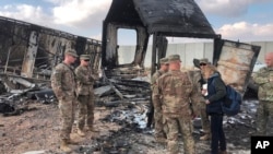 Soldados estadounidenses evalúan los daños en el sitio de un ataque con cohetes iraní en la base aérea de Ain al-Asad, en Anbar, Irak, el 13 de enero de 2020.