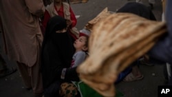 Seorang perempuan Afghanistan tampak meminta-minta di sebuah pasar di kota Kabul, Afghanistan, pada 14 September 2021. Banyak dari bantuan kemanusiaan yang hendak masuk ke negara tersebut namun mengalami penundaan. (Foto: AP/Bernat Armangue)
