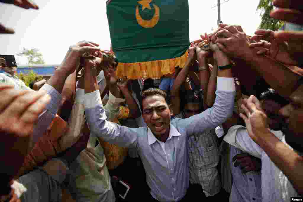 People carry a coffin during a funeral for the victims of a fire at Yaeway cemetery, Rangoon, Burma, April 2, 2013.