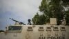 A Ugandan police officer serving with the African Union Mission in Somalia's first Formed Police Unit stands at the top of an armored personnel carrier at a police station in the capital Mogadishu, August 7, 2012.