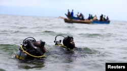 Les membres de l'unité maritime de la police de l'Ouganda participent aux efforts de secours après qu'un bateau transportant des réfugiés principalement congolais a chaviré dans le lac Albert sud-ouest de la capitale ougandaise, Kampala, 23 mars 2014.
