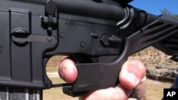 Instruktur Frankie McRae menunjukan pegangan pada senapan AR-15 yang sudah dipasang dengan "bump stock" di Klub Tembak 37 PSR di Bunnlevel, 4 Oktober 2017. 