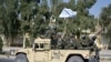 Pasukan Taliban dari Korps Militer Al-Badr duduk di atas kendaraan bersenjata dalam sebuah parade di Kandahar, Afghanistan, pada 8 November 2021. (Foto: AFP/Javeed Tanveer)