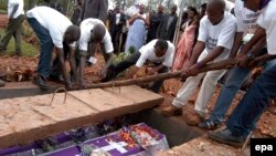 Des volontaires déposent dans un caveau les restes des victimes du génocide de 1994, à Murambi, Rwanda, le 07 avril 2005. epa / RICKY GARE