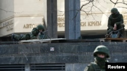 Tentara bersenjata berjaga di sekitar gedung parlemen di Simferopol, Krimea, Ukraina (1/3).