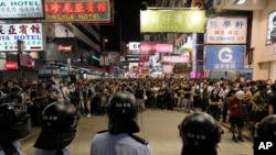 Polisi anti-huru-hara berhadapan dengan para demonstran di jalan utama distrik Mong Kok di Hong Kong (17/10). (AP/Vincent Yu)