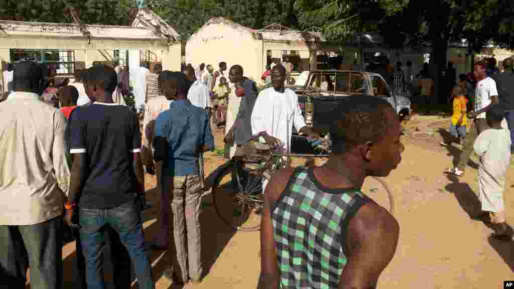 Mutane sun taru su na kallon inda aka kai harin bam cikin makarantar Sakandaren Kimiyya ta Gwamnati dake garin Potiskum a Jihar Yobe, Litinin 10 Nuwamba, 2014.